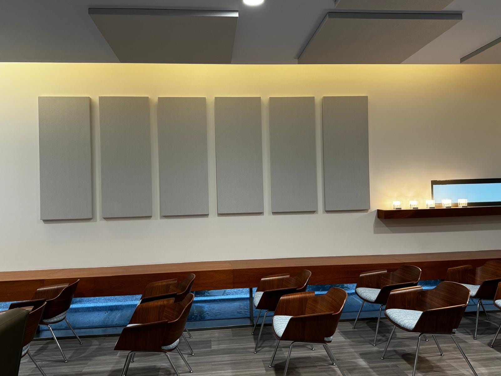 Row of grey fabric acoustic wall panels in a community room