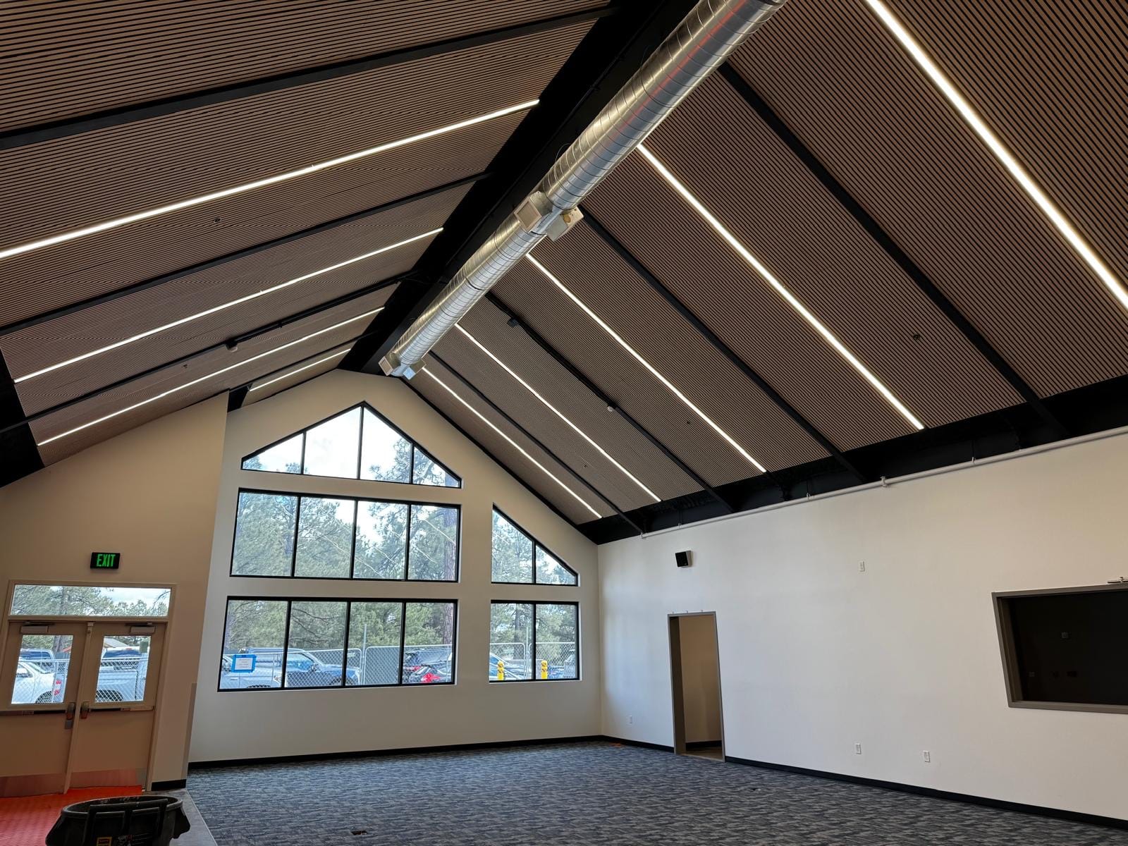 Acoustic treatment in a bright, beamed school commons